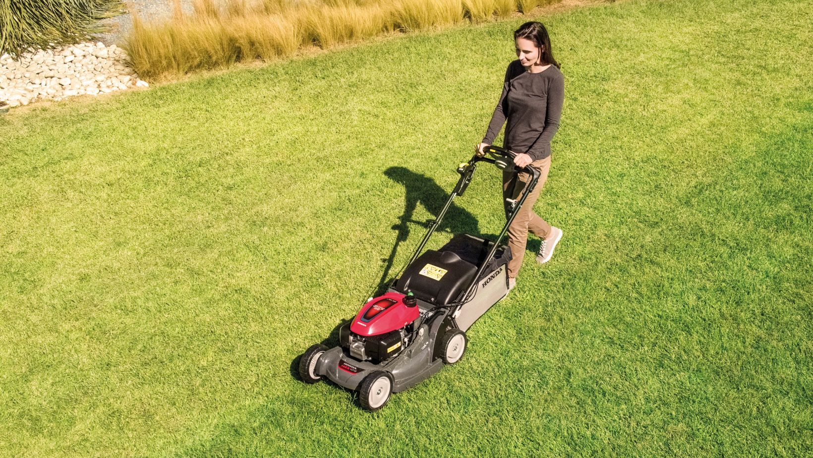an overhead shot of a woman mowing a lawn with a Honda HRX 476 Lawnmower