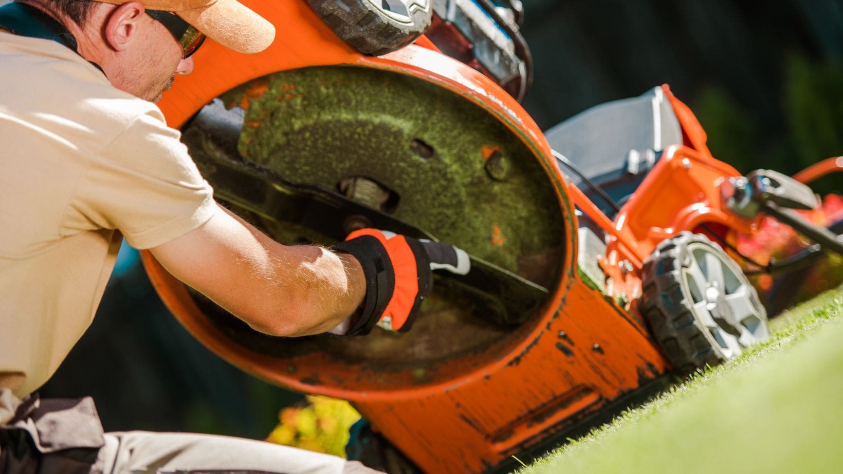 a man attaching a new blade to a lawnmower