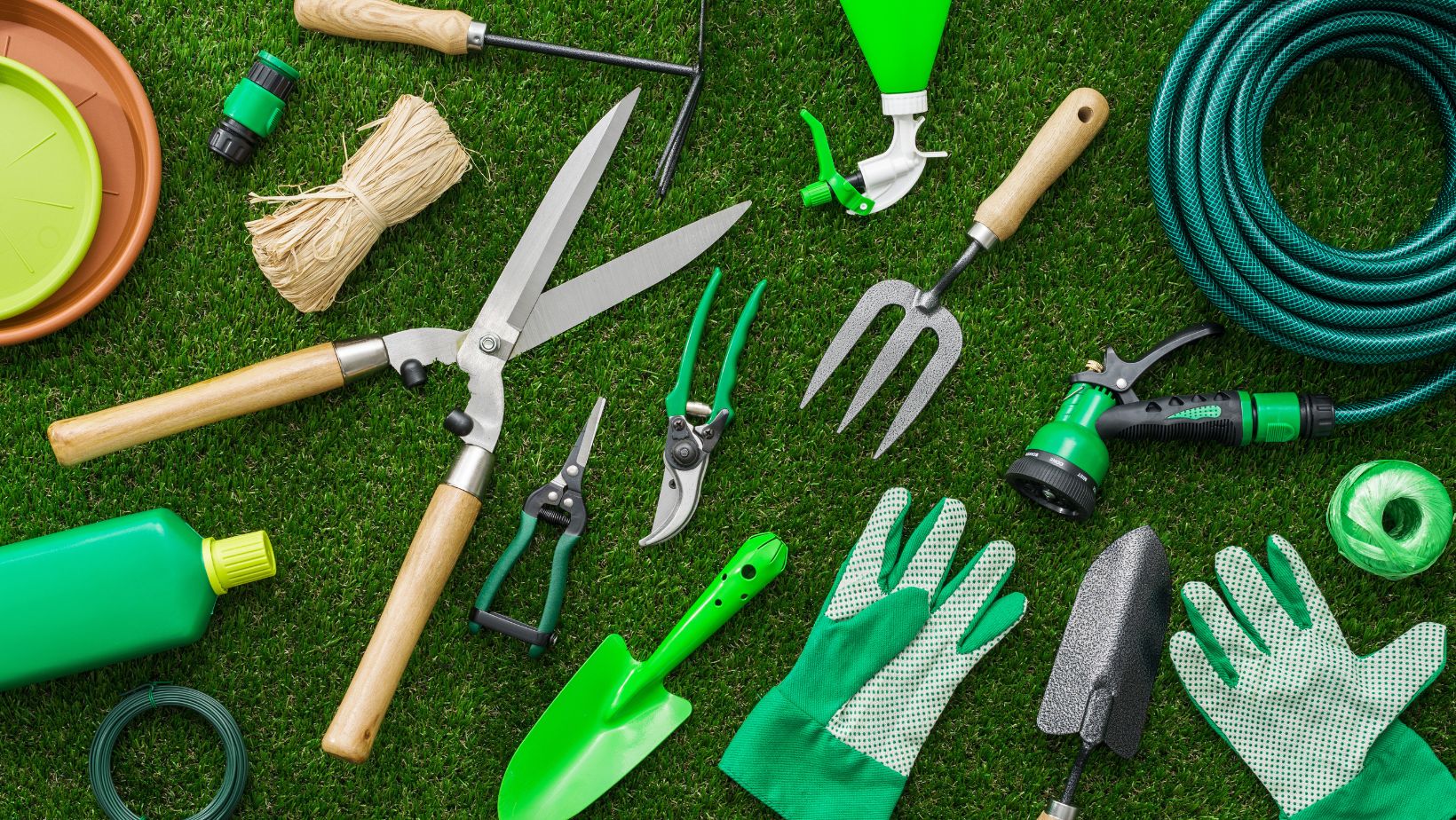a selection of garden tools laid out on a lawn